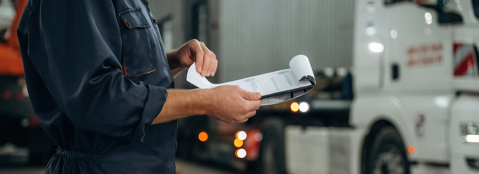 Conferência de romaneio de carga via documentos em prancheta.