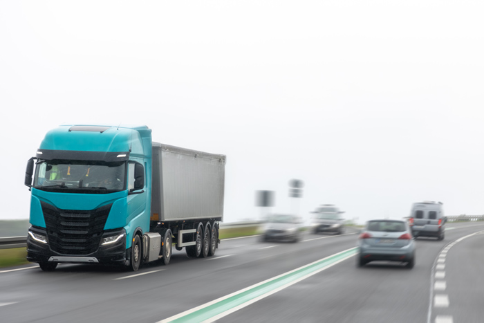 Caminhão em estrada de serra ao entardecer, exemplo de risco em direção perigosa em rodovias sinuosas