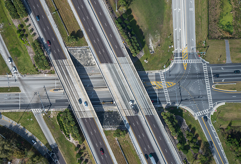 Imagem vista de cima de carros em rodovia, representando a gestão de risco para veículos.