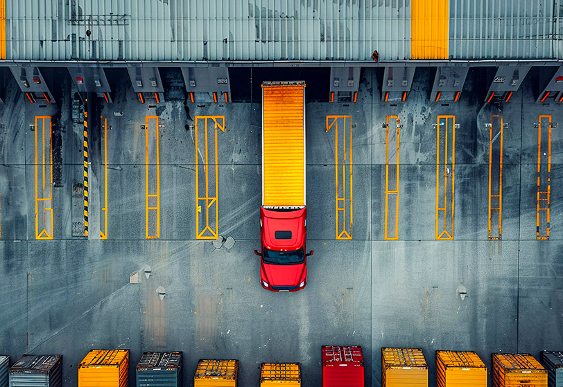 Foto de pátio de caminhões visto de cima, representando a gestão logística de operações.