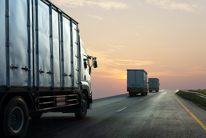 Caminhões trafegando ao amanhecer em uma rodovia, ilustrando como o tempo ocioso da frota impacta a gestão de tempo e a produtividade operacional.